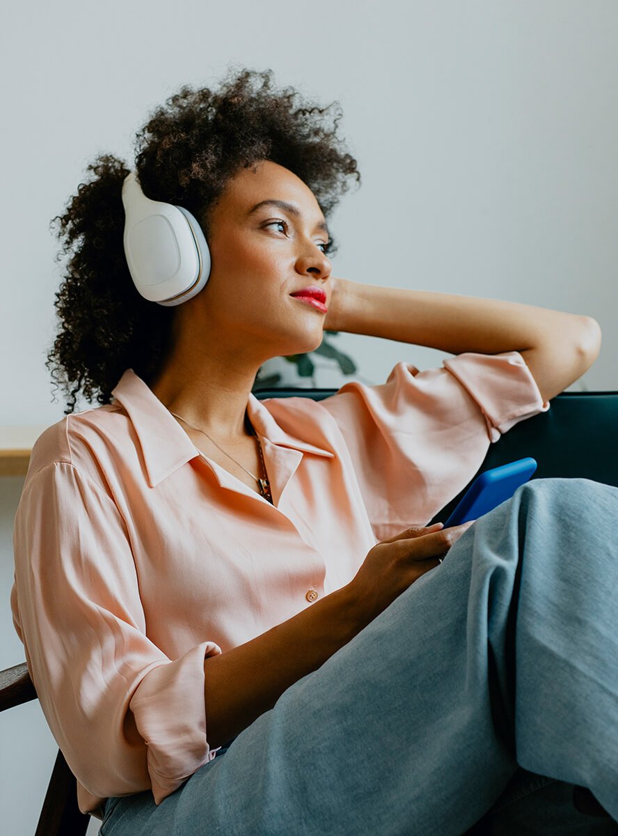 Young woman with mobile device wearing headphones